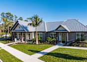 Thumbnail 27 of 32 - A modern house with a grey roof and a white fence.