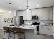 Thumbnail 1 of 32 - A modern kitchen with a white countertop and grey cabinets.