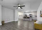 Thumbnail 3 of 32 - A spacious living room with a kitchen in the background.