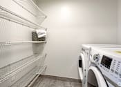 Thumbnail 23 of 30 - A white washing machine sits next to a metal shelf with a towel on it at Saba Pompano Beach, Pompano Beach, 33062