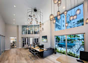 Thumbnail 9 of 30 - A modern office with a large window overlooking a pool and buildings at Saba Pompano Beach, Pompano Beach, 33062