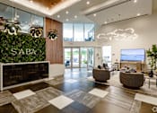 Thumbnail 1 of 30 - A modern lobby with a green wall and a reception desk at Saba Pompano Beach, Pompano Beach, 33062