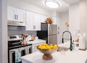 Thumbnail 3 of 16 - A kitchen with a bowl of lemons on the counter.