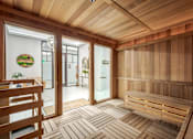 Thumbnail 24 of 36 - A wooden sauna room with a bench and a door.