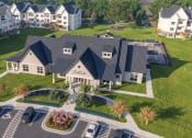 Thumbnail 24 of 29 - an aerial view of a house with a gray roof and a parking lot with cars