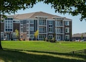 Thumbnail 29 of 30 - A large, modern building with a grassy lawn in front.