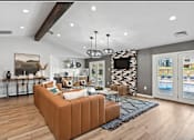 Thumbnail 1 of 13 - A living room with a brown sofa and a TV mounted on the wall.