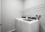 Thumbnail 21 of 51 - A white washing machine and dryer in a laundry room.