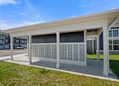 Thumbnail 46 of 51 - A modern building with a white roof and grey columns.