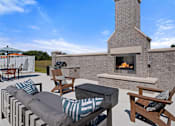 Thumbnail 44 of 51 - A patio with a fireplace and seating area.
