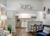Thumbnail 3 of 20 - A modern kitchen with a bar stool and a chair.