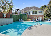 Thumbnail 22 of 33 - a swimming pool with a house in the background