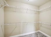 Thumbnail 23 of 39 - Empty white closet with shelves and hangers.