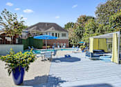 Thumbnail 21 of 33 - a backyard with a pool and patio with chairs and umbrellas