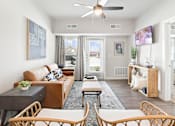 Thumbnail 5 of 30 - A living room with a brown couch and a ceiling fan.
