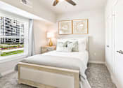 Thumbnail 9 of 30 - A bedroom with a bed, nightstand, and window.