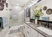 Thumbnail 6 of 24 - A bathroom with a white toilet, a sink, and a mirror.
