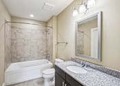 Thumbnail 20 of 39 - A bathroom with a white tub, toilet, and sink.