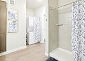 Thumbnail 10 of 30 - A bathroom with a white and blue shower curtain.