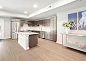 Thumbnail 15 of 30 - A modern kitchen with a wooden floor and white appliances.