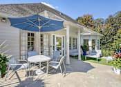 Thumbnail 26 of 33 - a patio with a table and chairs under an umbrella