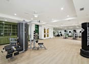 Thumbnail 8 of 39 - A gym with a variety of equipment including a squat rack, a leg press machine, and a bench press.