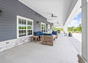 Thumbnail 23 of 30 - A patio with a white ceiling and a stone wall.