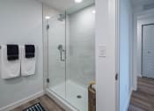 Thumbnail 24 of 78 - a bathroom with a glass shower and two towels on a rack at Altis Blue Lake, Lake Worth, Florida