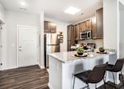 Thumbnail 2 of 51 - A kitchen with brown chairs and a white counter.