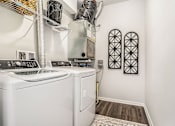 Thumbnail 9 of 51 - A white washing machine and dryer in a small laundry room.