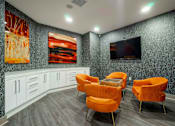 Thumbnail 4 of 22 - A room with orange chairs and a television on the wall.
