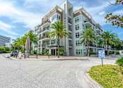 Thumbnail 21 of 22 - A modern apartment building with a blue sign in front.