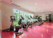 Thumbnail 13 of 22 - A gym with treadmills and elliptical machines.