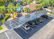 Thumbnail 24 of 25 - a row of cars parked under solar panels in a parking lot