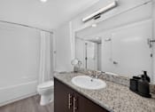 Thumbnail 16 of 35 - A white bathroom with a toilet, sink, and mirror.