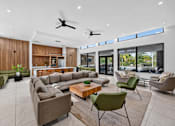 Thumbnail 24 of 35 - A modern living room with a large sectional sofa and a coffee table.