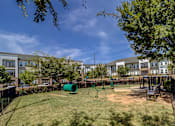 Thumbnail 45 of 53 - A playground with a green slide and a brown bench.