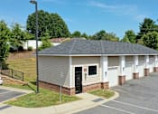 Thumbnail 48 of 53 - A small building with a parking lot in front.