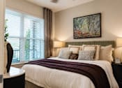 Thumbnail 20 of 40 - A bedroom with a large bed and a painting on the wall.