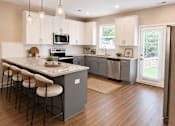 Thumbnail 10 of 71 - A spacious kitchen with marble countertops and bar top sitting