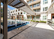 Thumbnail 26 of 30 - A modern building with a pool and a wooden pergola.