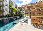 Thumbnail 25 of 30 - A pool with a slide and a wooden fence.