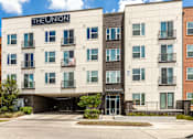 Thumbnail 29 of 30 - The Union apartment building with a parking lot in front.