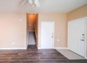 Thumbnail 56 of 69 - a living room with a door to a staircase and a ceiling fan