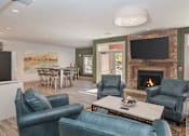 Thumbnail 8 of 37 - A living room with a fireplace and a television.
