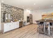 Thumbnail 16 of 37 - A modern kitchen with a stone wall and wooden flooring.