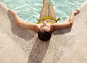 Thumbnail 13 of 28 - a woman laying in the water in a pool
