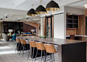 Thumbnail 6 of 24 - A modern kitchen with a long island and bar stools.