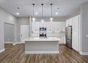 Thumbnail 19 of 24 - A modern kitchen with a center island and stainless steel appliances.