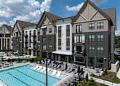 Thumbnail 26 of 26 - A large building with a pool in front of it.